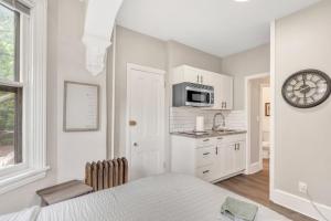 a kitchen with a bed and a clock on the wall at Trolley Teacup Charming Cozy Studio apts in Wilmington +22 photos