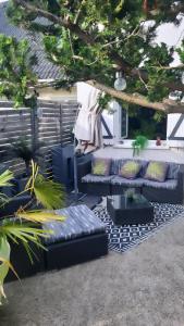 un patio con sofá, mesa y algunas plantas en Cosy & Style blue forest room proche CDG AirPort, en Tremblay-en-France