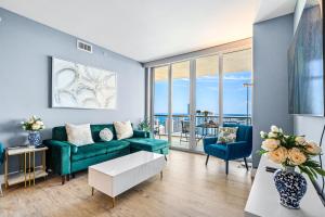 a living room with a green couch and blue chairs at Ocean Views - Pool & Gym - Pet Friendly - Close to Beach in Hallandale Beach