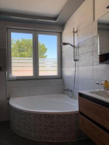 a bathroom with a tub and a window and a sink at Schicke Apartments in Messenähe in Hannover