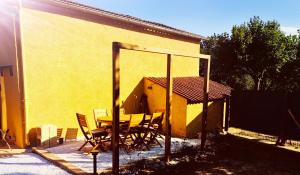 a table and chairs in front of a yellow building at La casita in Ongles