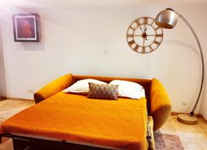 a bed in a room with a clock on the wall at La casita in Ongles