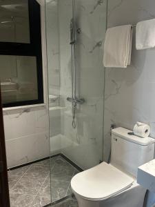 a bathroom with a toilet and a glass shower at Eco Nest Hotel & Apartment in Hanoi