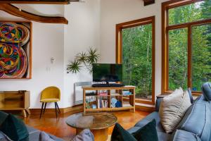 a living room with a blue couch and a tv at Le Sculptural Spa, billiards, firepit & pool in Val-David
