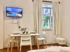 ein Wohnzimmer mit einem Tisch und einem Fernseher an der Wand in der Unterkunft Departamento en Microcentro Ciudad de Buenos Aires in Buenos Aires
