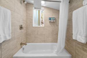 a white bath tub in a bathroom with a window at Big Bear Frontier in Big Bear Lake +108 photos