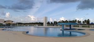 a swimming pool with a blue bench in the middle at Apartamento no Villa das Águas in Estância