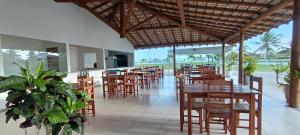 a restaurant with wooden tables and chairs and a balcony at Apartamento no Villa das Águas in Estância