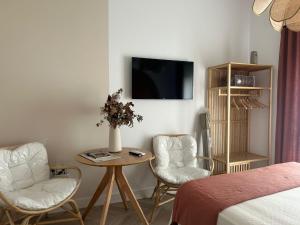 a room with two chairs and a table and a tv at Sol de Zafra Estudio in Zafra