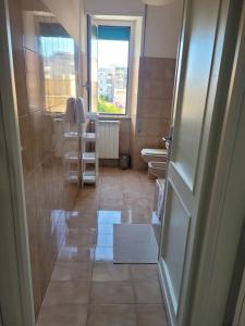 a bathroom with a toilet and a window and a door at Cavour3 in Nettuno +41 photos