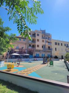 a playground in front of a large building at Cavour3 in Nettuno +36 photos