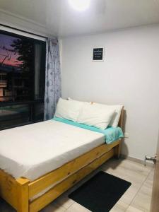 a small bed in a room with a window at Habitaciones Armenia Quindio in Armenia