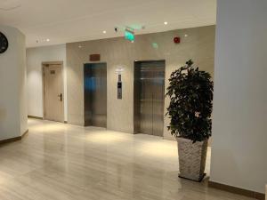 a hallway with a potted plant in a building at Al Furat Madayin Hotel in Riyadh