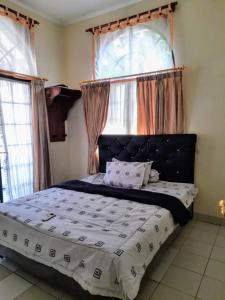 普卡Villa Sa'adah 2的一间卧室配有一张带窗户的大床