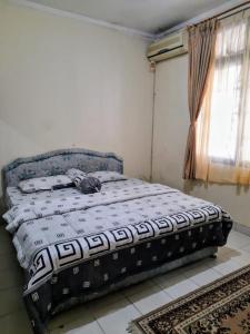 普卡Villa Sa'adah 2的一张位于带窗户的房间的床 更多2张照片