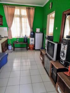 普卡Villa Sa'adah 2的客厅拥有绿色的墙壁和白色的瓷砖地板。