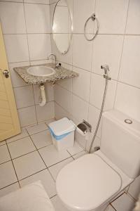 La salle de bains est pourvue de toilettes, d'un lavabo et d'un miroir. dans l'établissement Pousada Asa Branca, à Mossoró