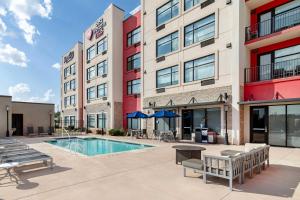a hotel patio with a pool and tables and benches at Best Western Plus Executive Residency Rigby's Water World Hotel in Warner Robins