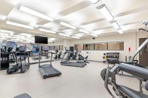 a gym with tread machines and a flat screen tv at Best Western Plus Executive Residency Rigby's Water World Hotel in Warner Robins