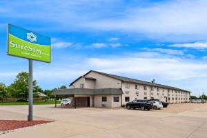 a sign for a hotel with cars parked in a parking lot at SureStay Hotel by Best Western Manchester in Manchester