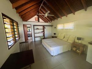 una camera con letto bianco e soffitto di Turtle Bay Beach House a Saraotou