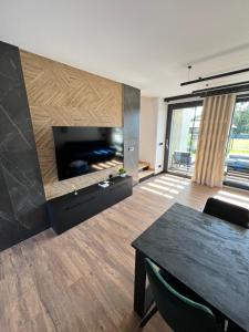 a living room with a large flat screen tv at Mazurskie Niebo Apartament 2 in Gołdap