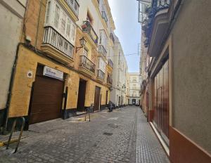 pusta alejka z budynkami i osobą idącą ulicą w obiekcie Casa Populi entre Catedral y Ayuntamiento w Kadyksie +4 zdjęcia
