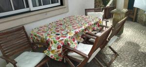 a table with a flowered table cloth on a patio at Quarto privado 5 in Famões