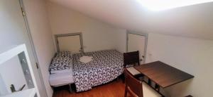 a small room with two beds and a table at Quarto privado 5 in Famões