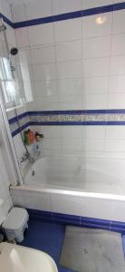 a bathroom with a white tub and a toilet at Quarto privado 5 in Famões
