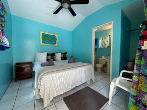 a bedroom with a bed and a ceiling fan at Barefoot Beach Belize in Caye Caulker