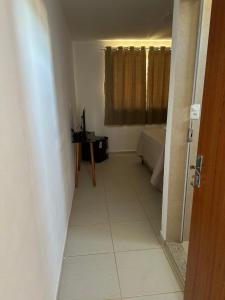 a room with a hallway with a table and a window at Suítes Grãos do Alto Caparaó in Caparaó Velho