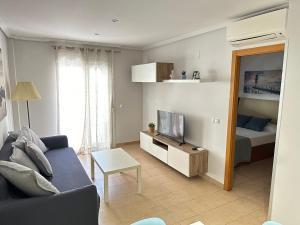 a living room with a couch and a tv and a bed at Casa Candelaria in Benidorm