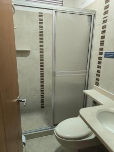 a bathroom with a shower and a toilet and a sink at Hotel Palmarito in Tauramena +13 photos