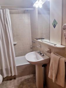 a bathroom with a sink and a shower and a tub at Urbana Class Hotel in Mendoza