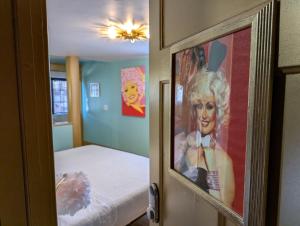 a bedroom with a bed and a painting of a woman at The Queen Hotel- Downtown Luxury in Sturgeon Bay +51 photos