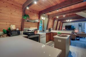 a large kitchen with wooden walls and a living room at Rhododendron Family Cabin Hot Tub and Deck! in Rhododendron