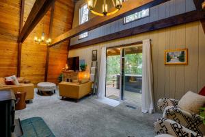 a living room with a sliding glass door to a patio at Rhododendron Family Cabin Hot Tub and Deck! in Rhododendron