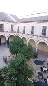 a building with a courtyard with tables and an umbrella at Duplex convento la victoria in Sanlúcar de Barrameda