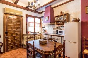 a kitchen with a wooden table and a refrigerator at Las Cuevas Del Abismo in Alcalá del Júcar