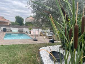 a backyard with a swimming pool and a wooden deck at Studio Cosy in Castanet-Tolosan