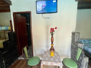 un tavolo con un vaso di fiori in una stanza di Hostal San Andrés de k-noa a Canoa