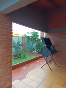 a black chair sitting in a room with a brick wall at Apart la hermosa in Puerto Iguazú