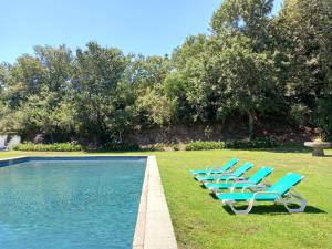 a row of blue lounge chairs next to a swimming pool at Casa dos Pinheiros - Pinheiros Farm House in Fafe