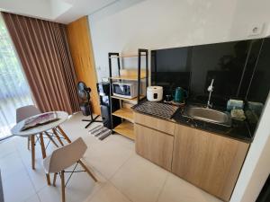 een keuken met een spoelbak en een aanrechtblad bij de' Asasta Apartment Benoa E216 in Nusa Dua