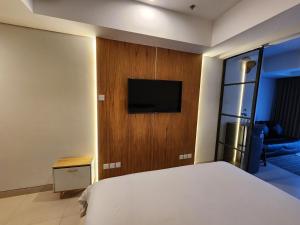 een slaapkamer met een bed en een flatscreen-tv bij de' Asasta Apartment Benoa E216 in Nusa Dua