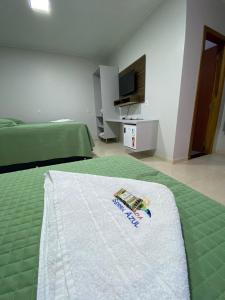 a hotel room with a bed with a towel on it at Pousada Serra Azul in Estivado