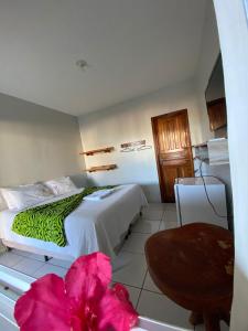a bedroom with a large bed with a pink flower at Pousada Serra Azul in Estivado +54 photos