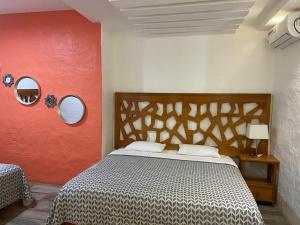 a bedroom with a bed and a red wall at Suitehome in Bahía de la Academia