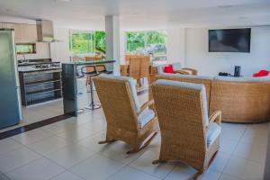 a kitchen and dining room with wicker chairs and a table at Finca Casa Blanca in Armenia